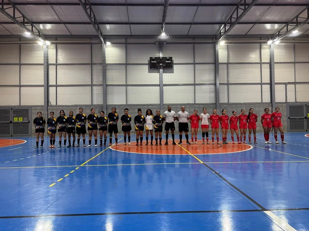 As duas equipes e a arbitragem perfiladas no centro da quadra antes do jogo