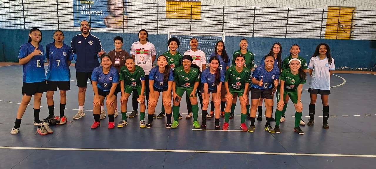 Atletas do Futsal feminino e da equipe adversária reunidas na quadra depois da partida