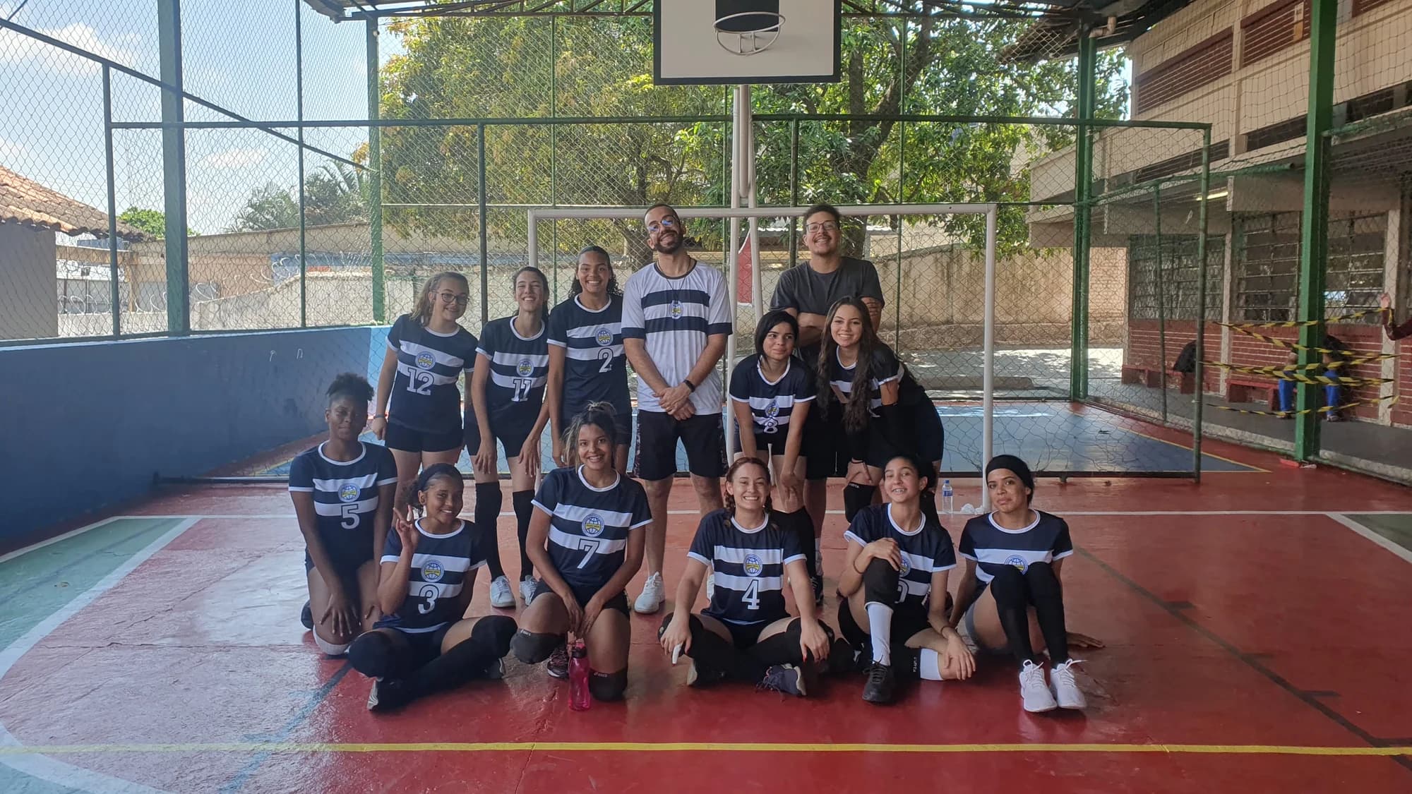 O primeiro time do projeto reunido na quadra da escola, com a comissão técnica